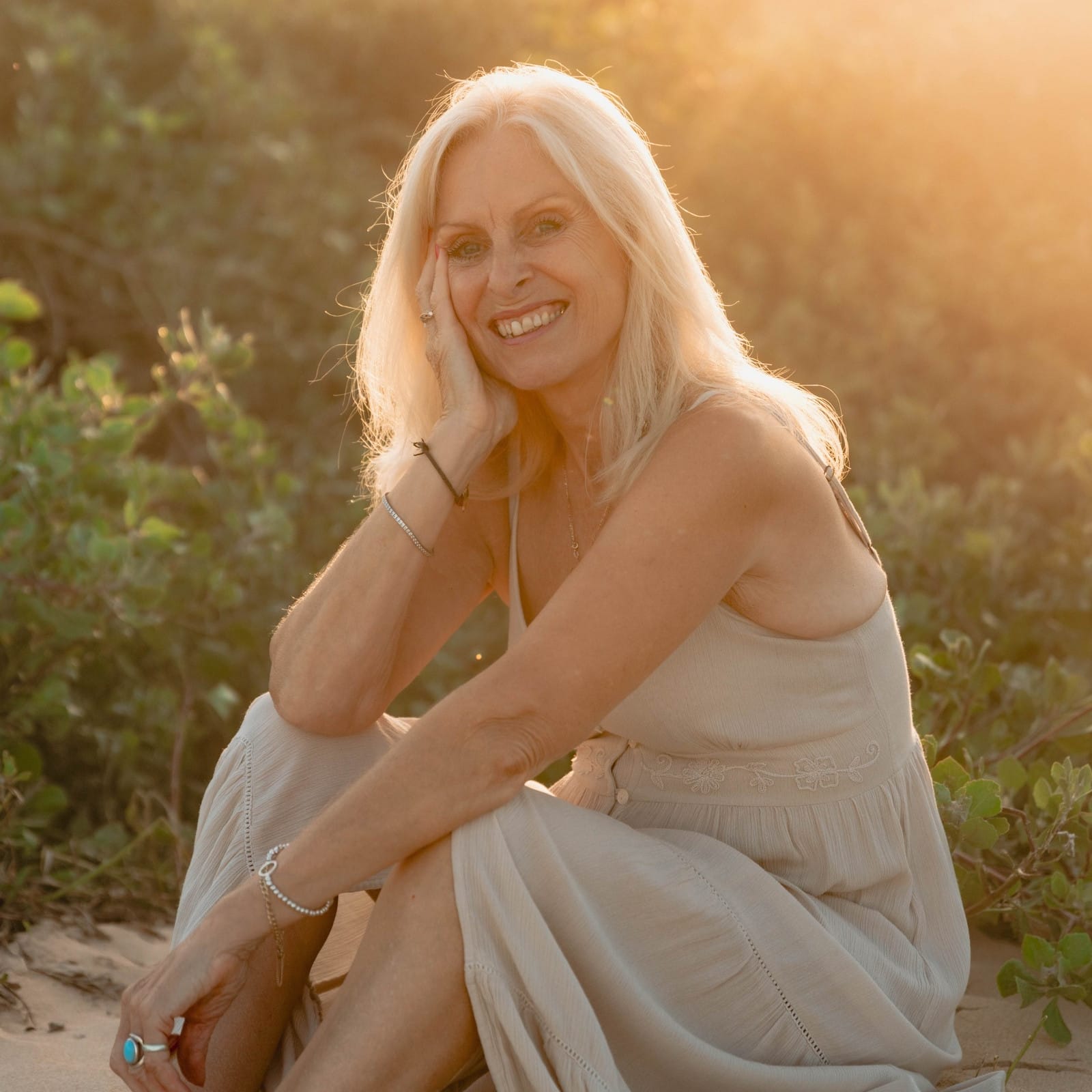 Val Hood, an Evidential Medium, relaxes on the beach, soaking in the sun and the calming sounds of the waves.